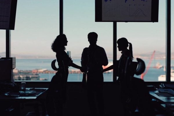 3 people with port in the background