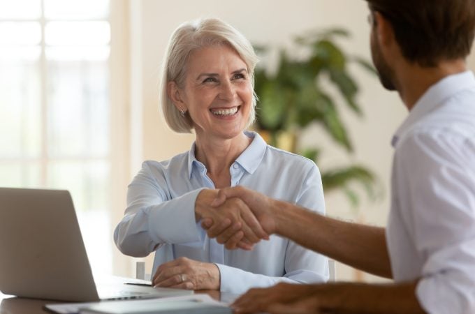 Smiling,Old,Mature,Saleswoman,Handshake,Businessman,Client,Customer,Hire,Job Secure. Coordinated. Efficient.